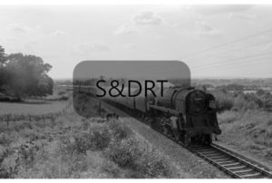 Corfe Mullen; 92000 on Down 'Pines Express' on bank, 12 carriages, summer 1961; G A Richardson